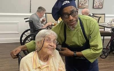 senior care staff assisting seniors meal